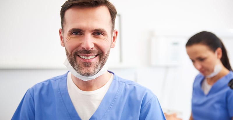 Portrait of smiling doctors standing in row at hospital premises