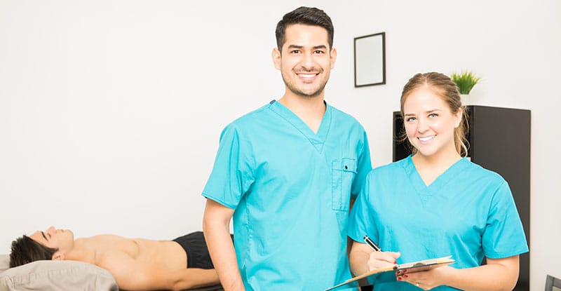 Portrait of smiling doctors standing in row at hospital premises